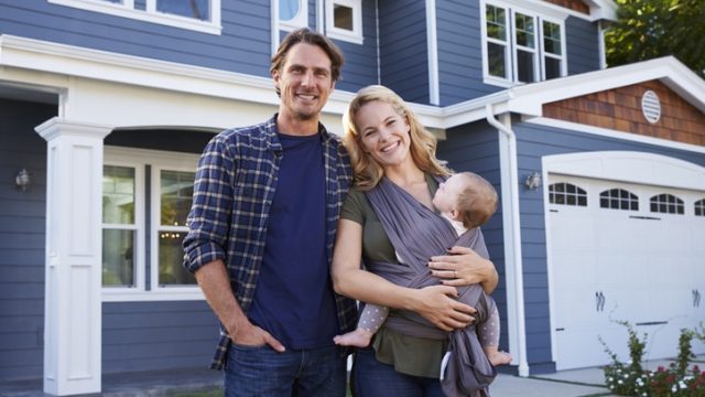 Portrait Of Family Standing Outside House